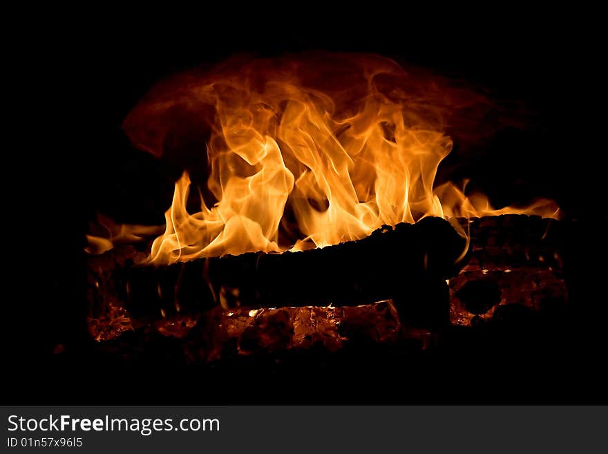 Burning wooden fire wood in the furnace on a black background. Burning wooden fire wood in the furnace on a black background