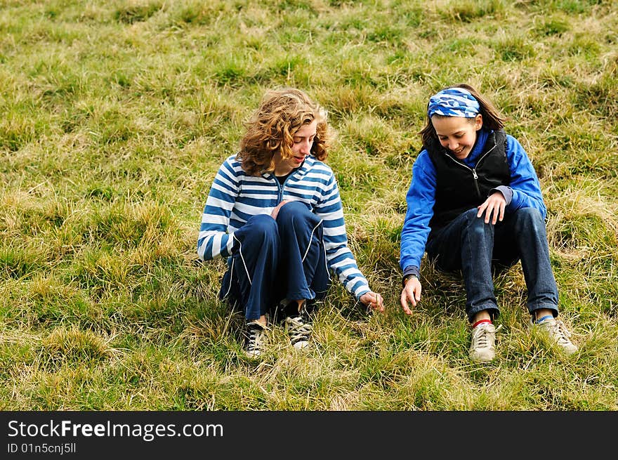 Portrait of friends sitting on grass and chatting. Portrait of friends sitting on grass and chatting