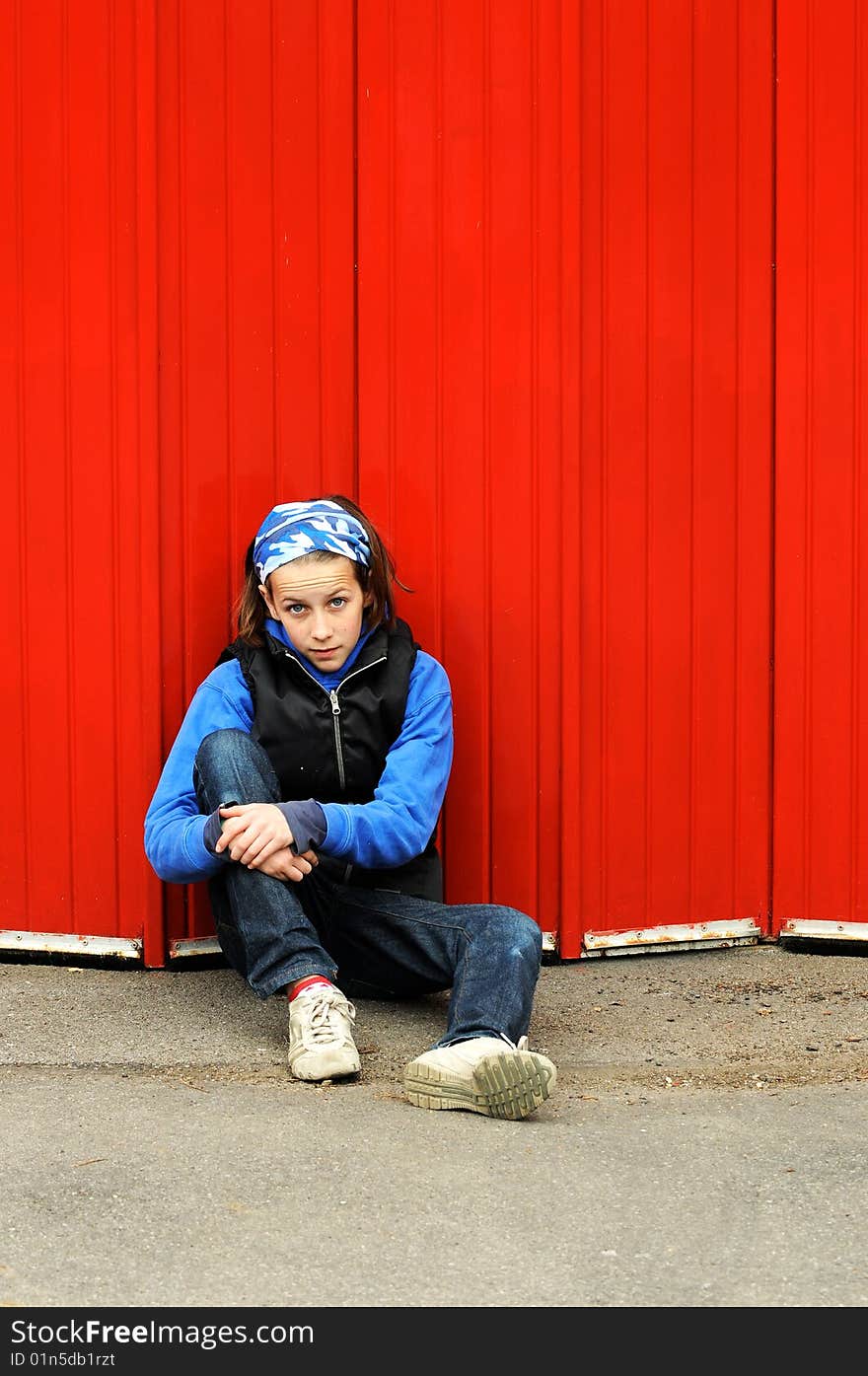 Portrait of modern child leaning against red wall. Portrait of modern child leaning against red wall