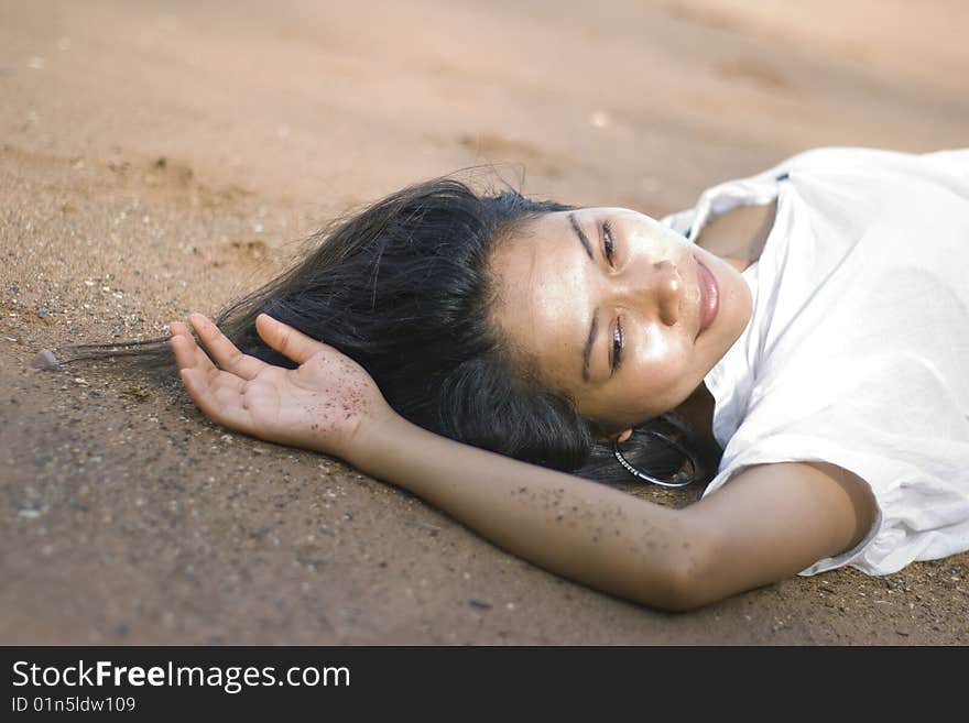 Pretty girl in casual clothes laying on the beach. Pretty girl in casual clothes laying on the beach.