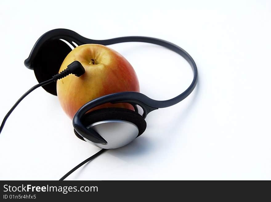 Apple and headphones on white background - mp3 player concept. Apple and headphones on white background - mp3 player concept