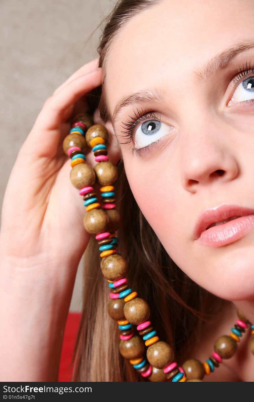 Beautiful female model with blue eyes and a string beads