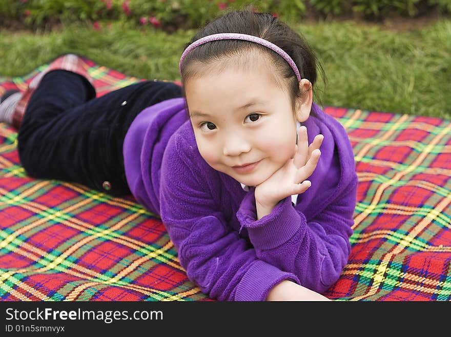 A girl lying on a picnic mat rest. A girl lying on a picnic mat rest