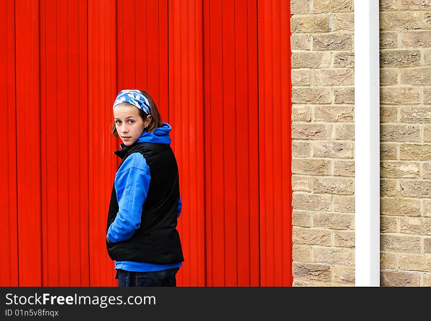 Teenage girl by red wall