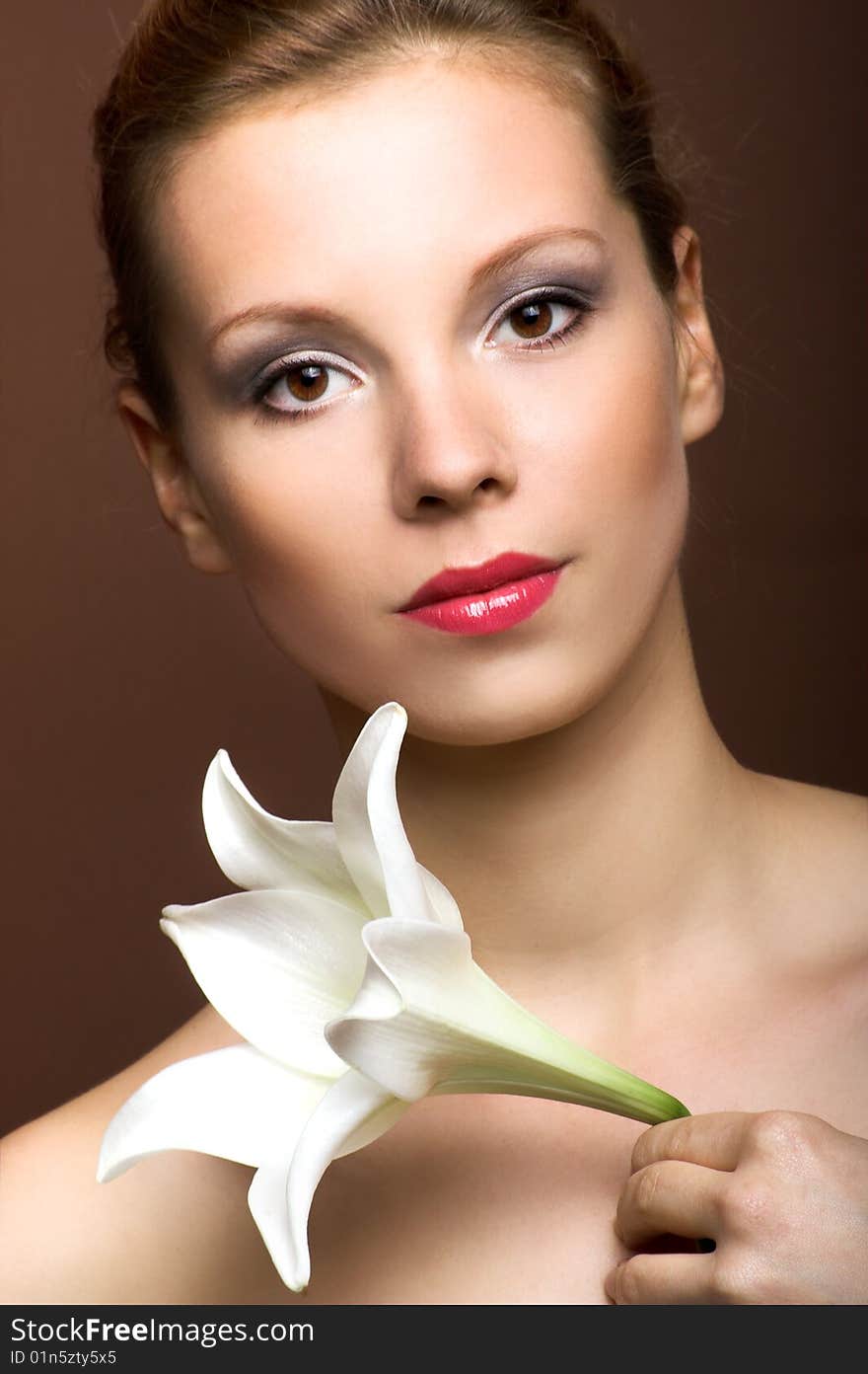 Beauty portrait of a young woman with a lily flower. Beauty portrait of a young woman with a lily flower