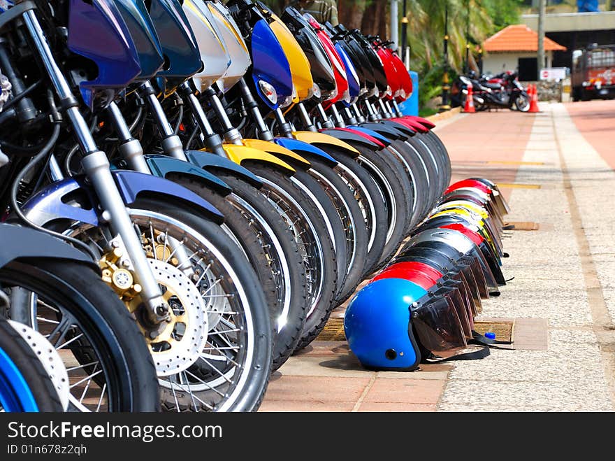 Row of Motorcycles Parked on Street and Row of Helmet. Row of Motorcycles Parked on Street and Row of Helmet.