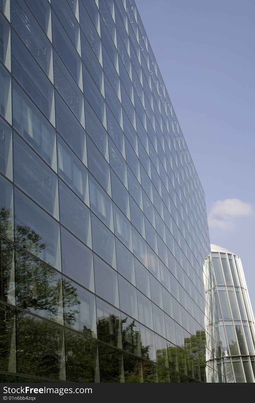 A business building with trees reflected
on its facade. A business building with trees reflected
on its facade