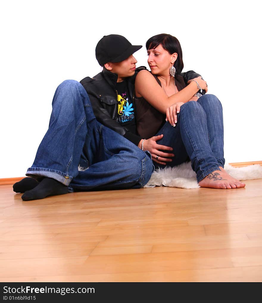 Young stylish couple sitting on the floor of their new home! Pure white wall leaves big copyspace. Young stylish couple sitting on the floor of their new home! Pure white wall leaves big copyspace.