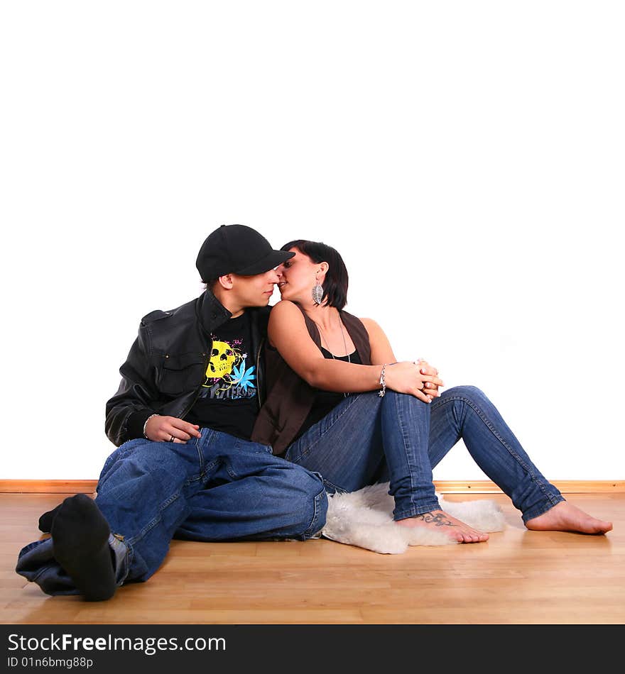 Young stylish couple kissing on the floor of their new home!. Young stylish couple kissing on the floor of their new home!