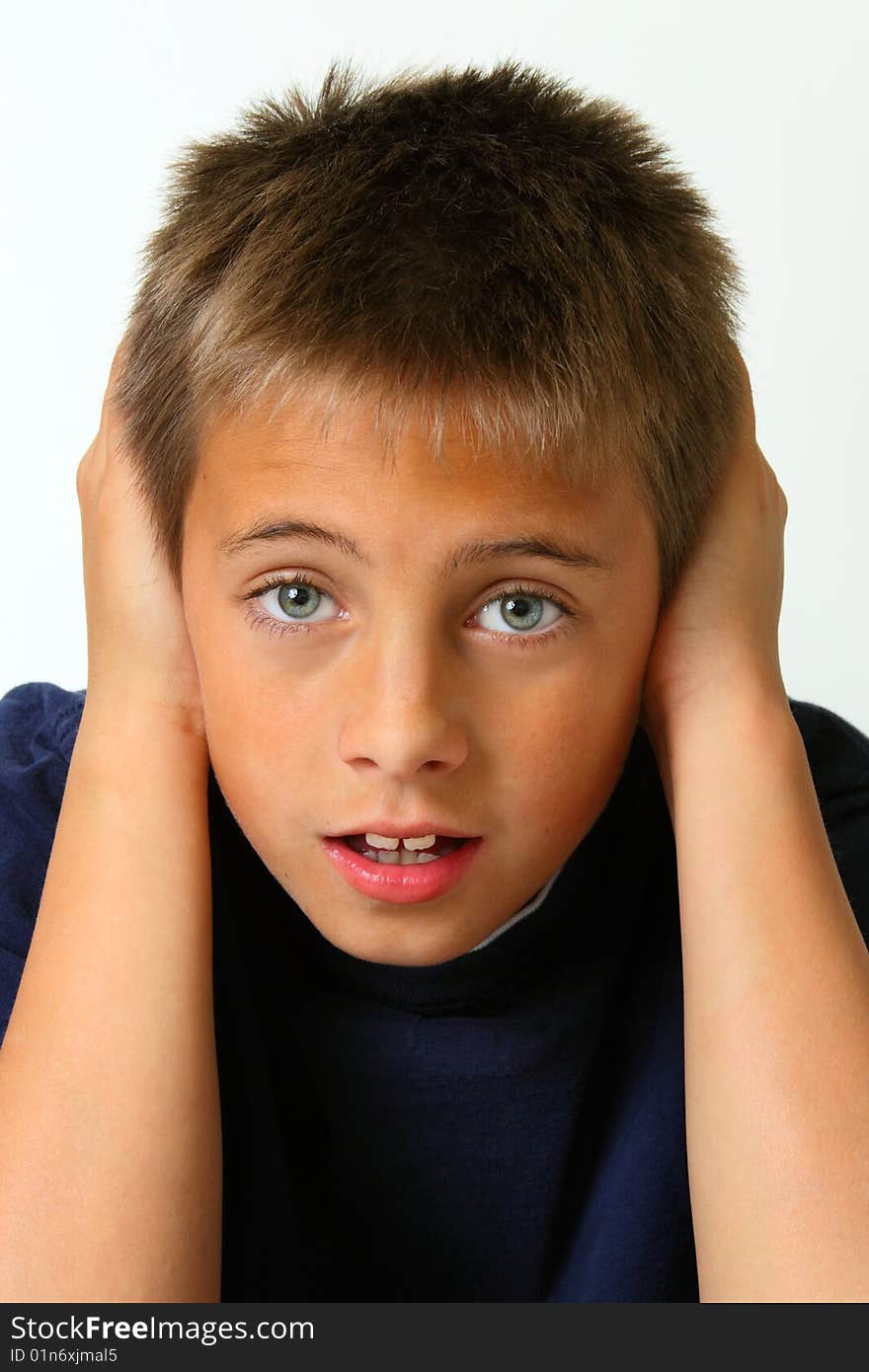 Boy covering ears against white background. Boy covering ears against white background