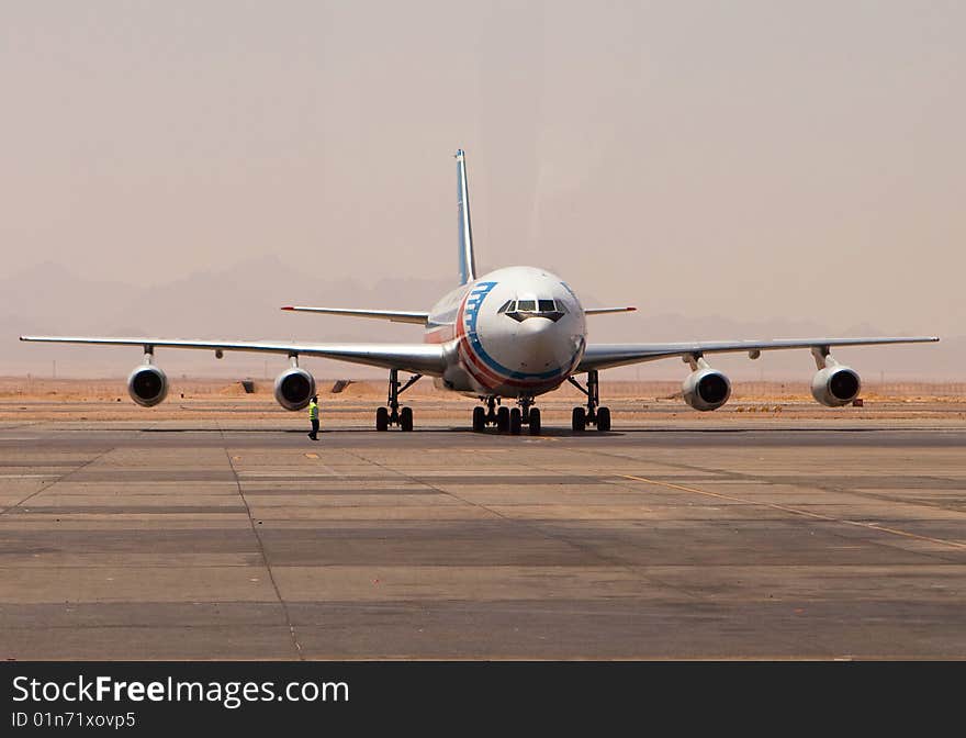 The plane being on an airport runway. The plane being on an airport runway