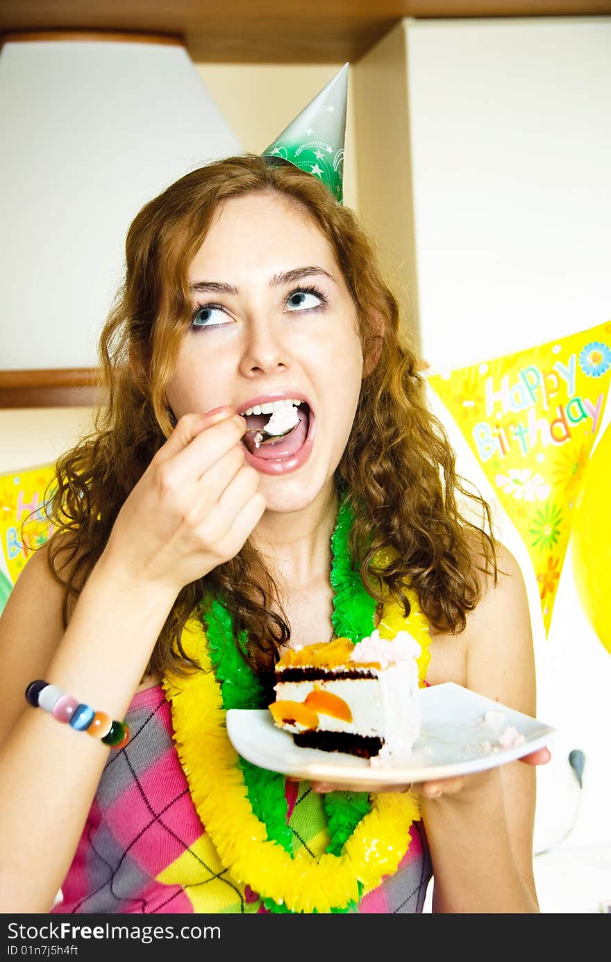 Portrait of a happy girl celebrating birthday and eating a cake