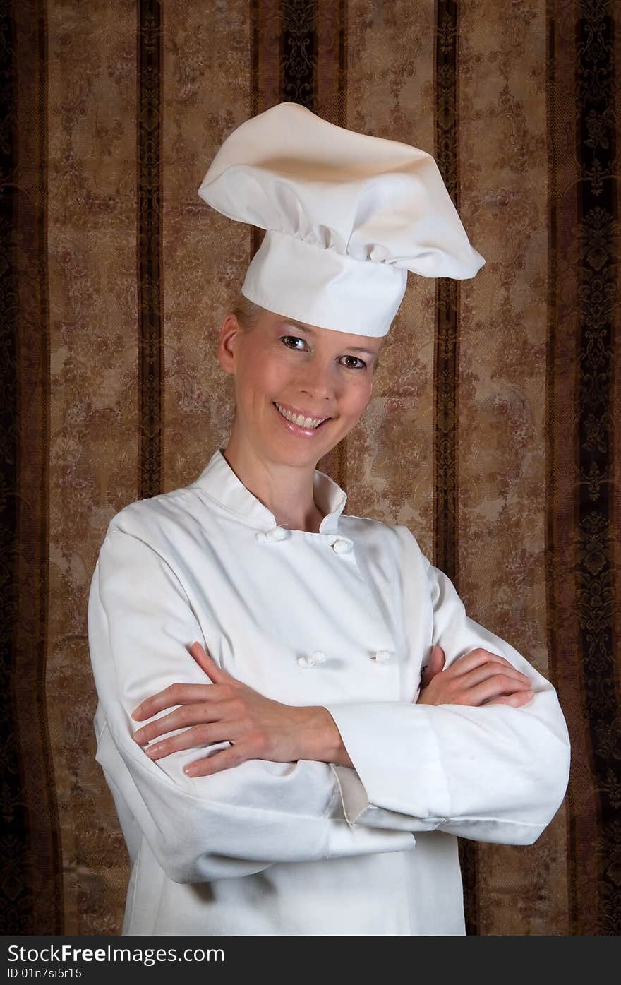 Assertive posed portrait of an attractive female Executive Chef proudly standing against an elegant background. Assertive posed portrait of an attractive female Executive Chef proudly standing against an elegant background.