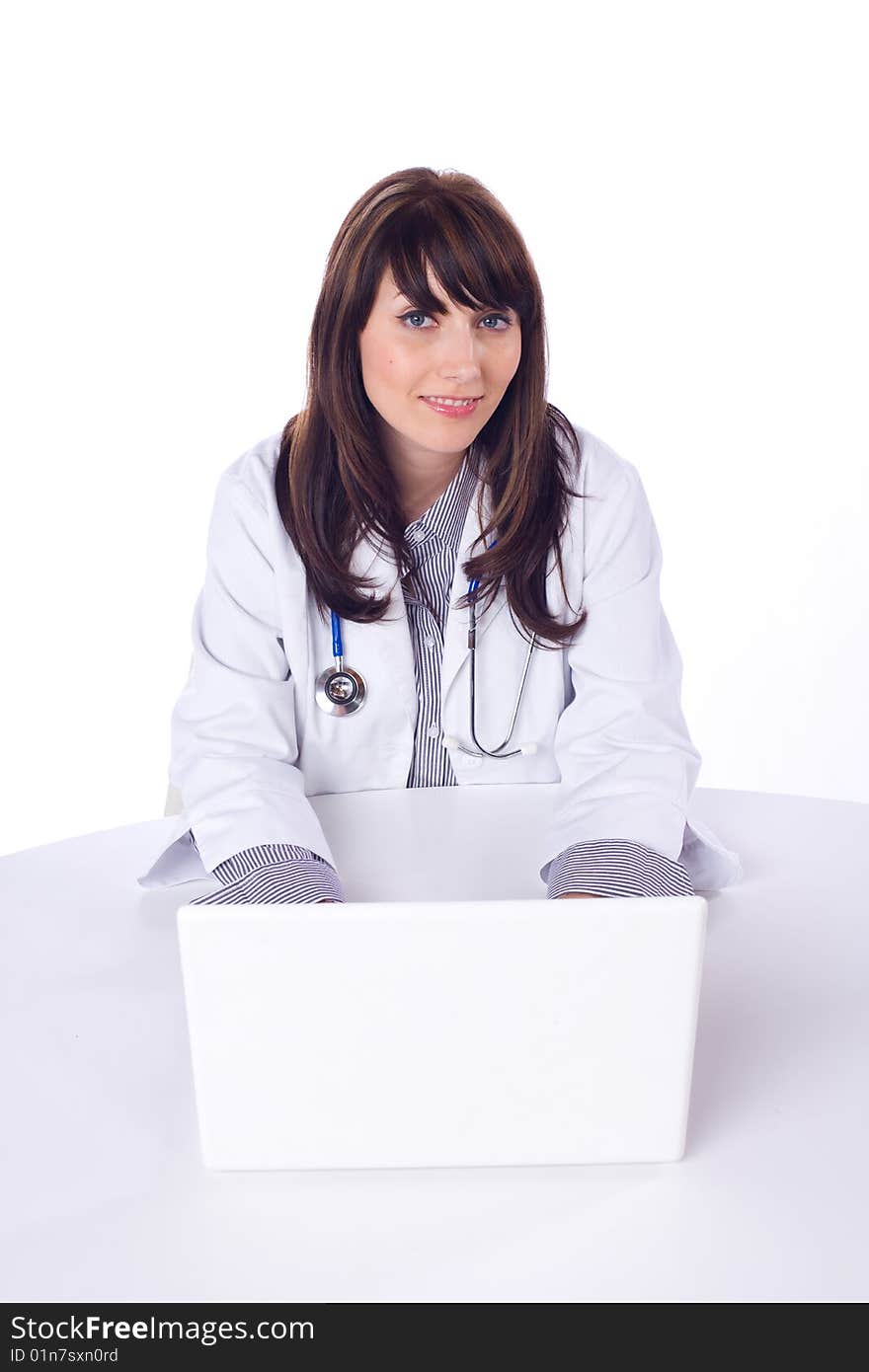 Female doctor on computer at desk isolated on white