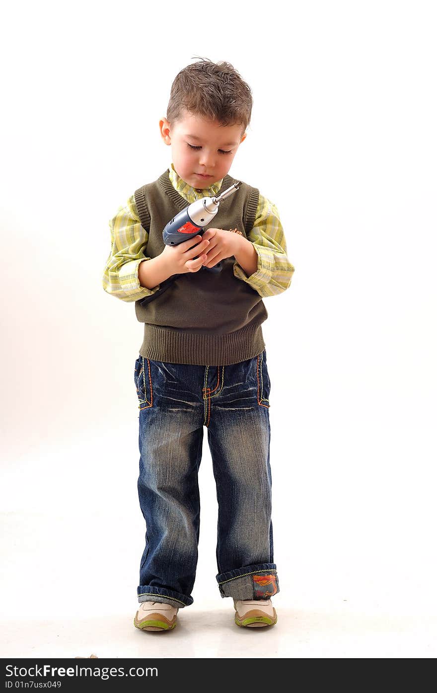 Small boy analyzing construction tool