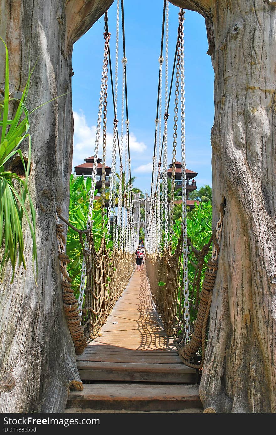 Wooden suspension bridge leading to paradise island, with hotels and resorts in the background. Wooden suspension bridge leading to paradise island, with hotels and resorts in the background