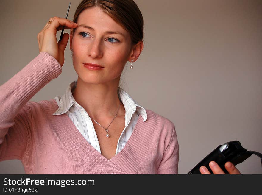 Attractive thoughtful woman holding a pda. Attractive thoughtful woman holding a pda