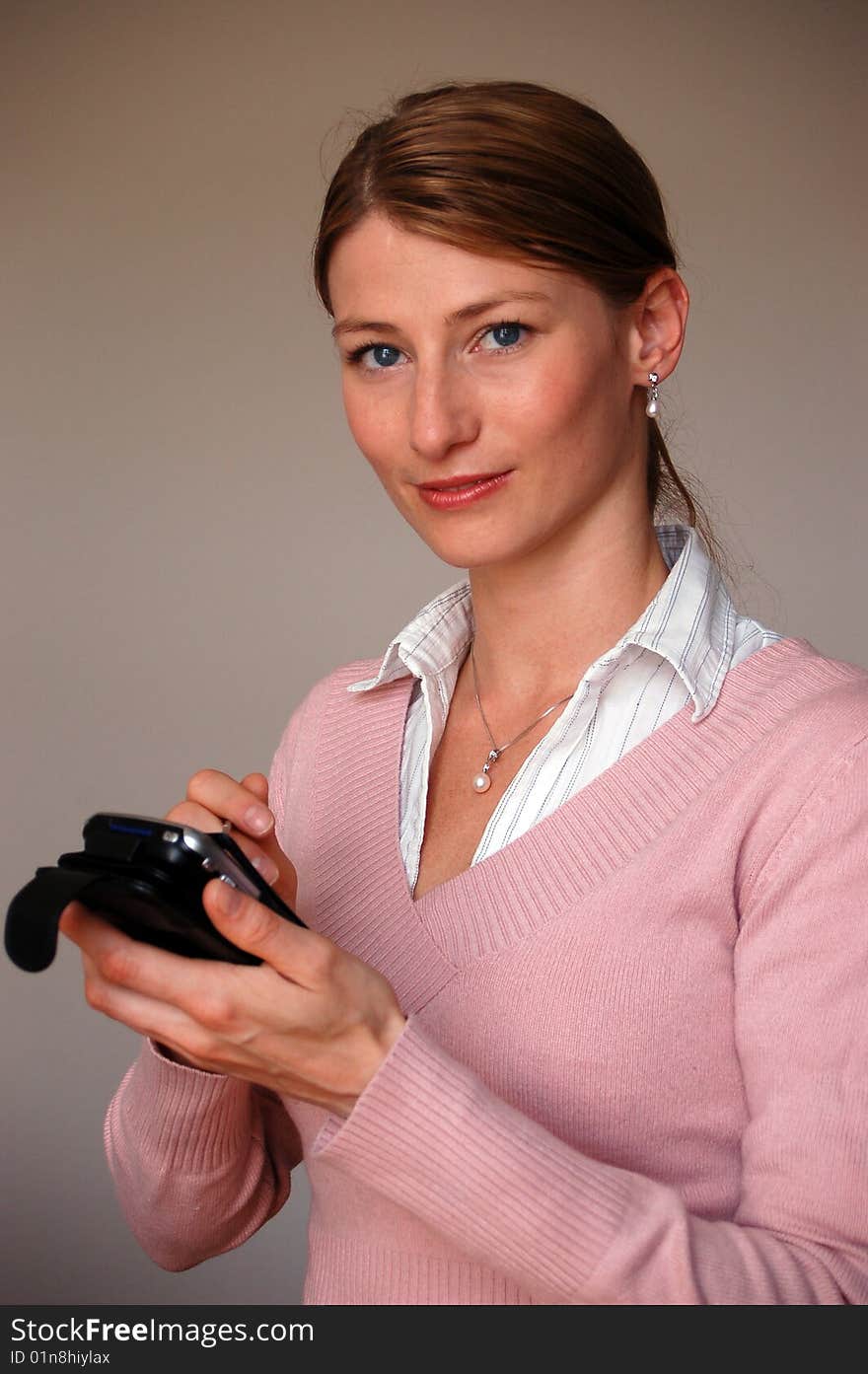 Attractive thoughtful woman holding a pda. Attractive thoughtful woman holding a pda