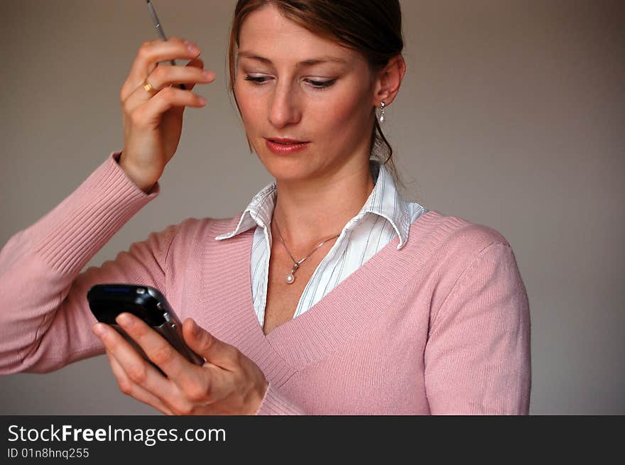 Attractive thoughtful woman holding a pda. Attractive thoughtful woman holding a pda