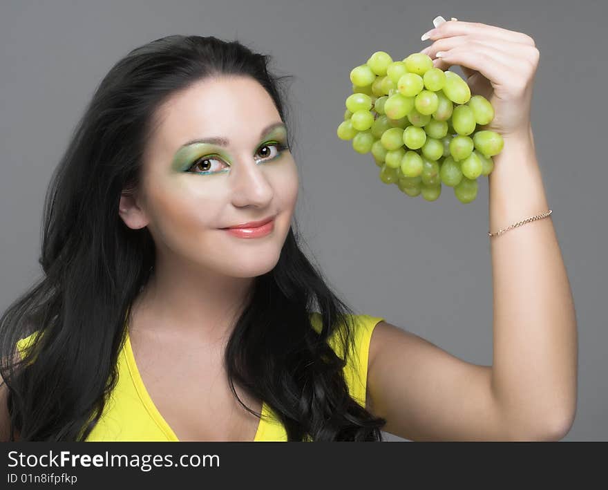 Portrait of young brunette with green grapes. Portrait of young brunette with green grapes