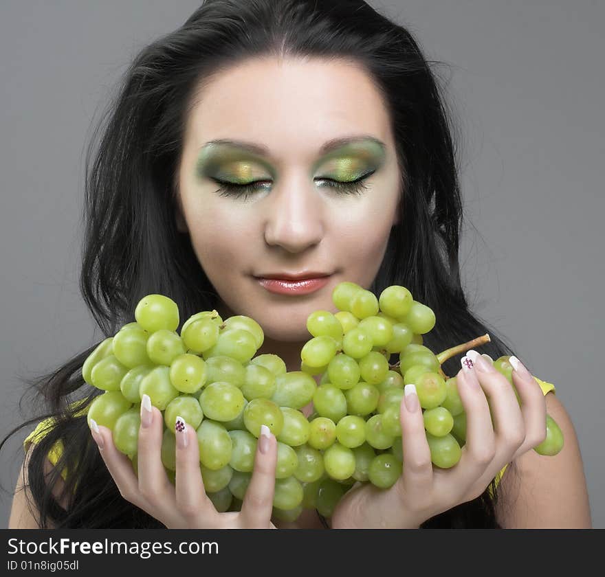 Portrait of young brunette with green grapes. Portrait of young brunette with green grapes