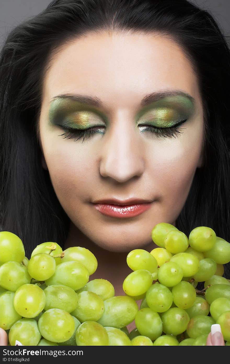 Portrait of young brunette with green grapes. Portrait of young brunette with green grapes