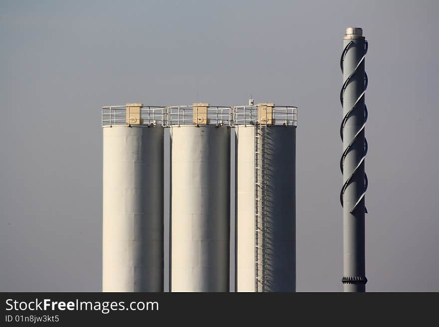 Chimney and cisterns on gray sky background