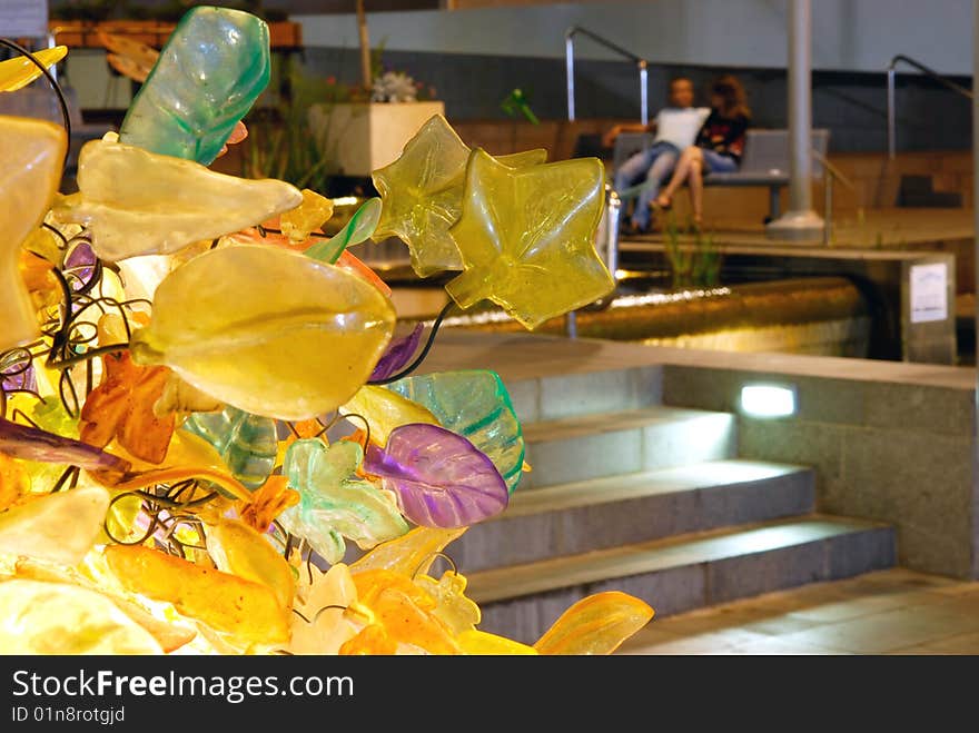 Couple sitting on a bench on the background of glass leafs. Couple sitting on a bench on the background of glass leafs