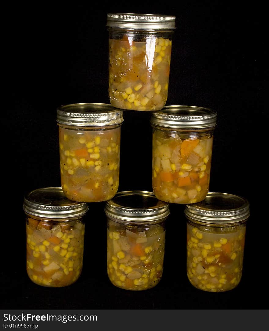 Canned vegetable soup on black background placed in a pyramid