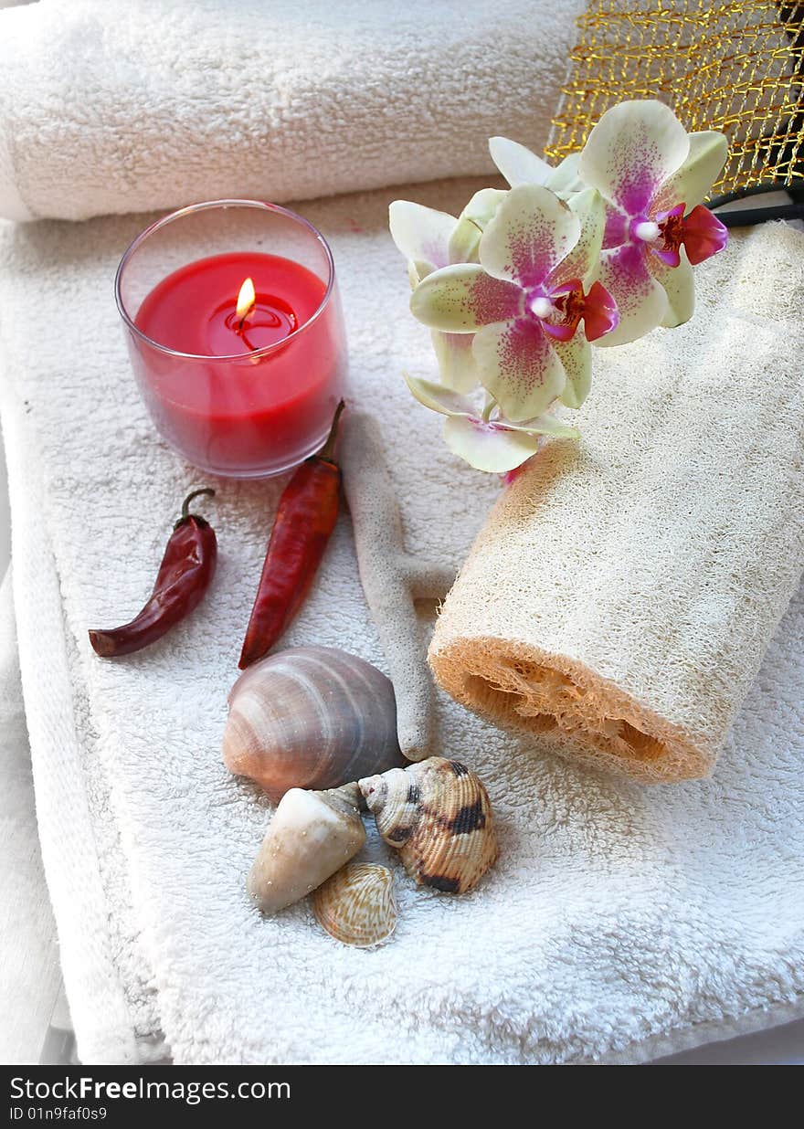 Towels, candle, orchid, and bath sponge in a spa. Towels, candle, orchid, and bath sponge in a spa