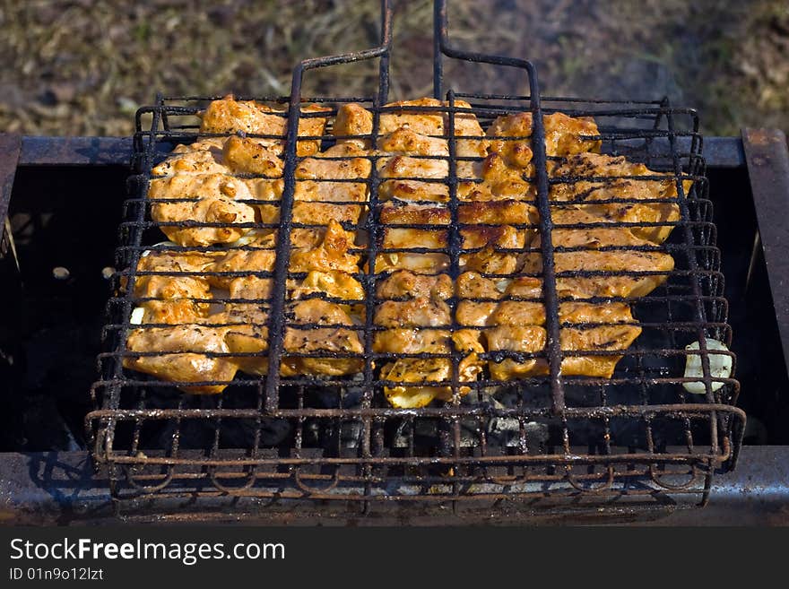 Sizzling hot meat, fried on a lattice above coal