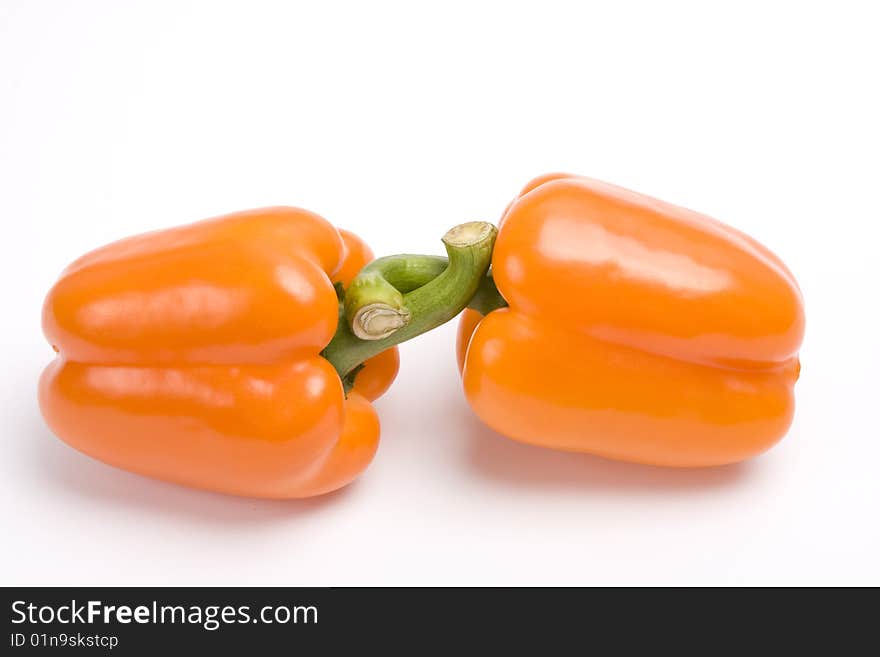 Two orange sweet peppers. Isolated over white background. Amorous twosomes of colorful sweet peppers.