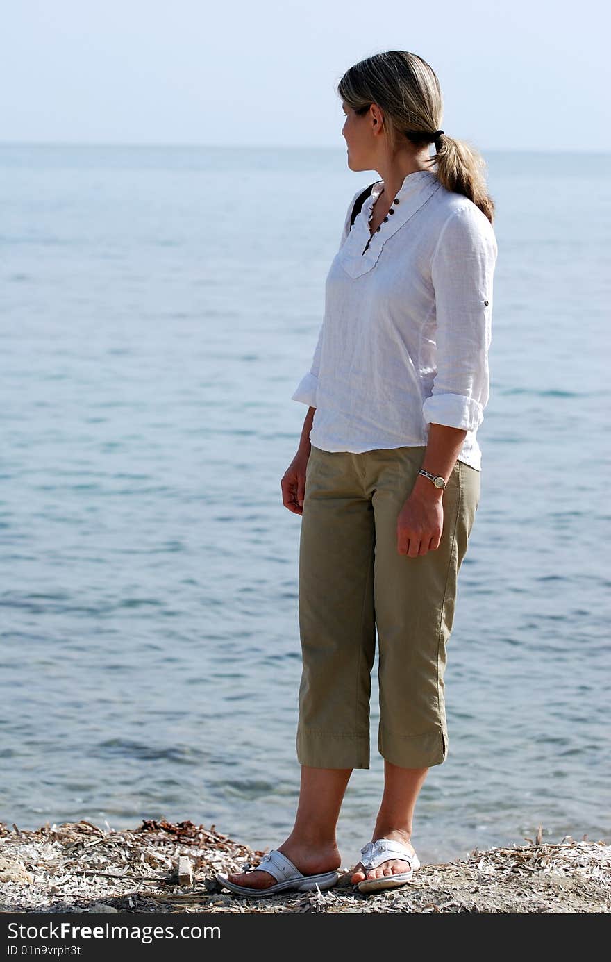 The girl enjoying the sea view on Katokolon town beach (Greece). The girl enjoying the sea view on Katokolon town beach (Greece).