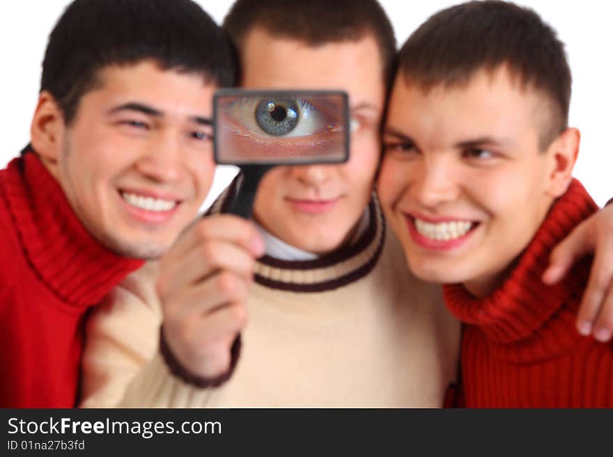 Three friends look through magnifier on white