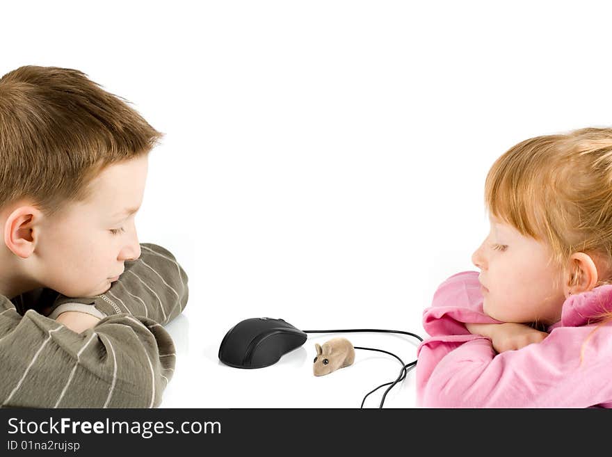 Young boy and girl looking at a toy mouse and computer mouse. Young boy and girl looking at a toy mouse and computer mouse