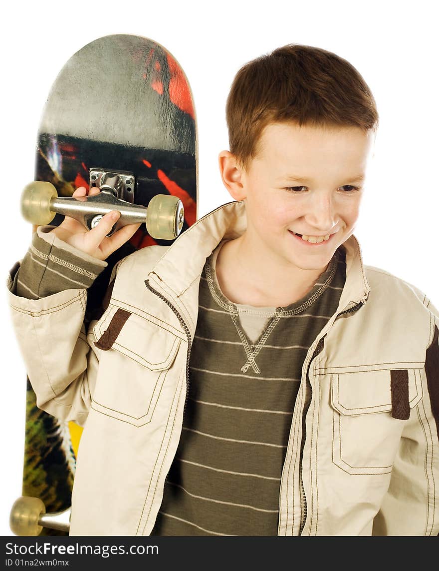 Smiling young boy holding skateboard on back