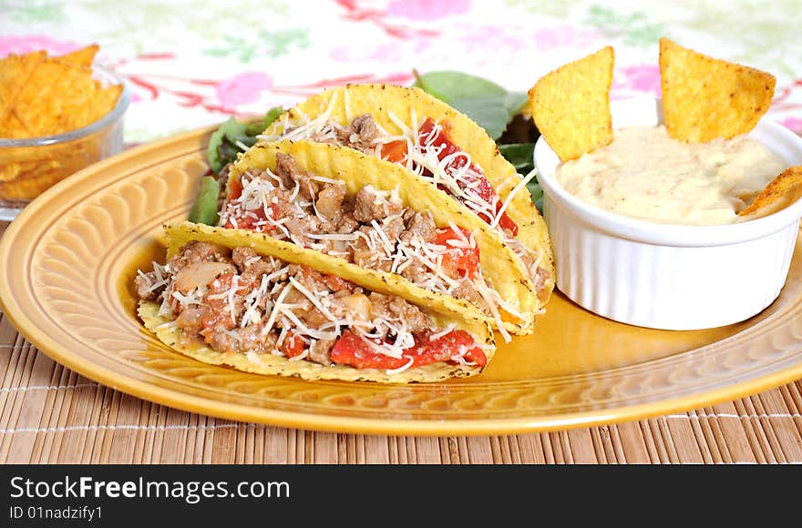 Tacos filled with minced meat peppers and cheese  - guacamole sauce on side. Tacos filled with minced meat peppers and cheese  - guacamole sauce on side