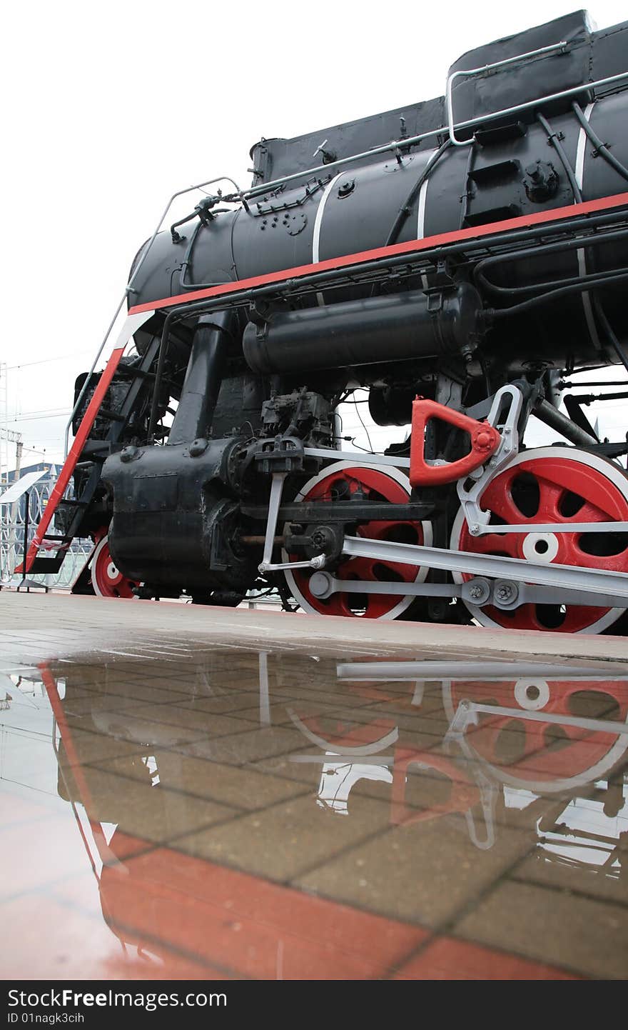 Steam locomotive and its reflection in puddle