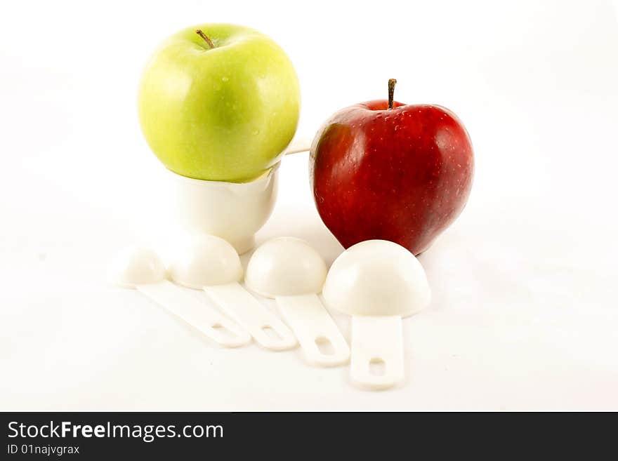 Two apples among measuring cup showing that they outweigh their sizes with nutrition value. Two apples among measuring cup showing that they outweigh their sizes with nutrition value