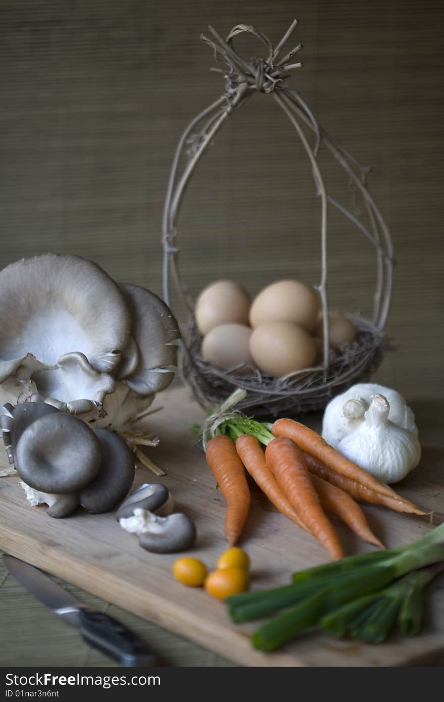 Fresh organic vegetables, eggs, and citrus on a chopping block. Fresh organic vegetables, eggs, and citrus on a chopping block