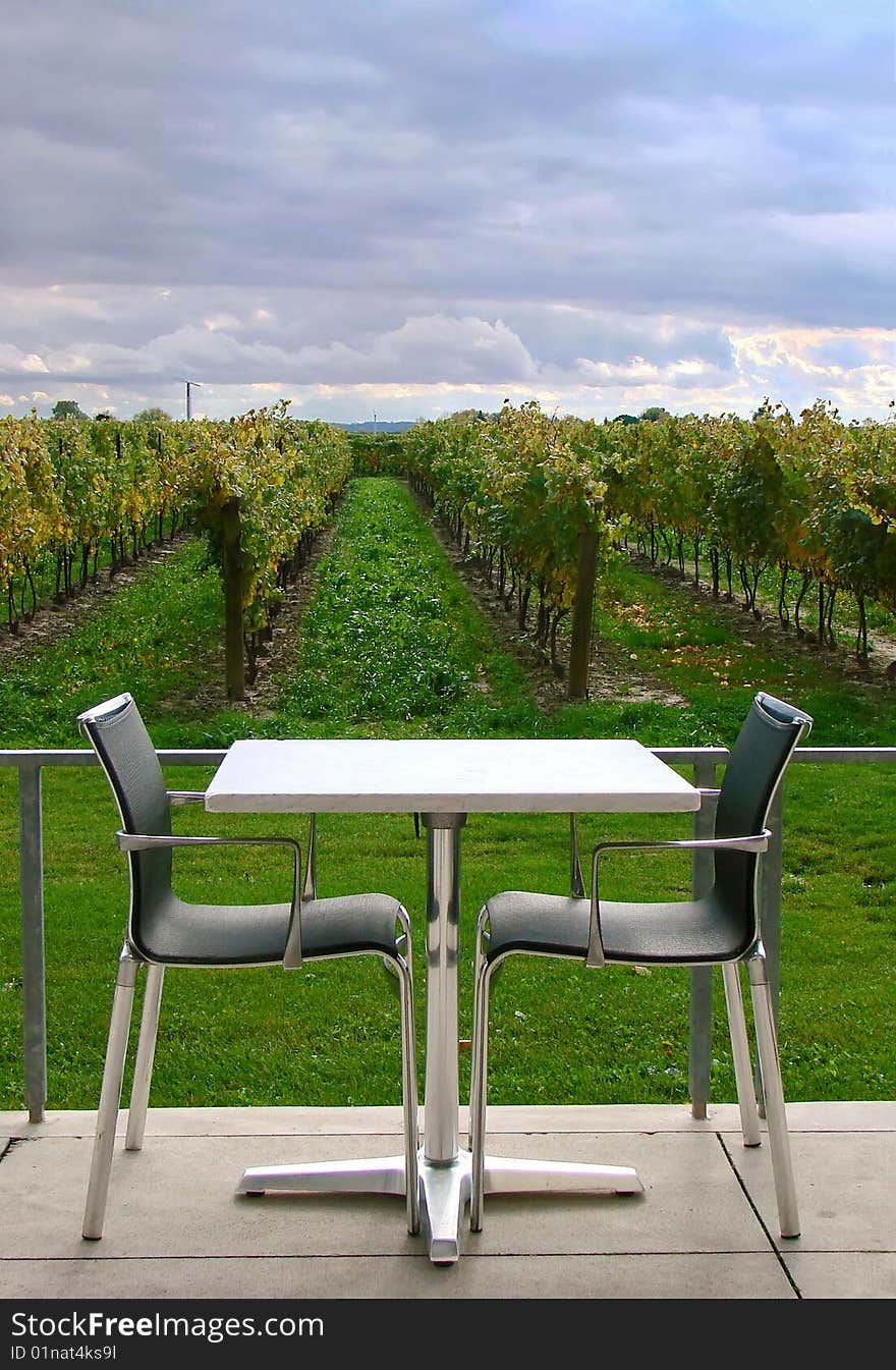 An empty table for two on a patio overlooking a vineyard. An empty table for two on a patio overlooking a vineyard