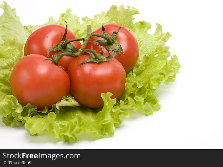 Group red tomato on leaf lettuce. Isolated over white background.