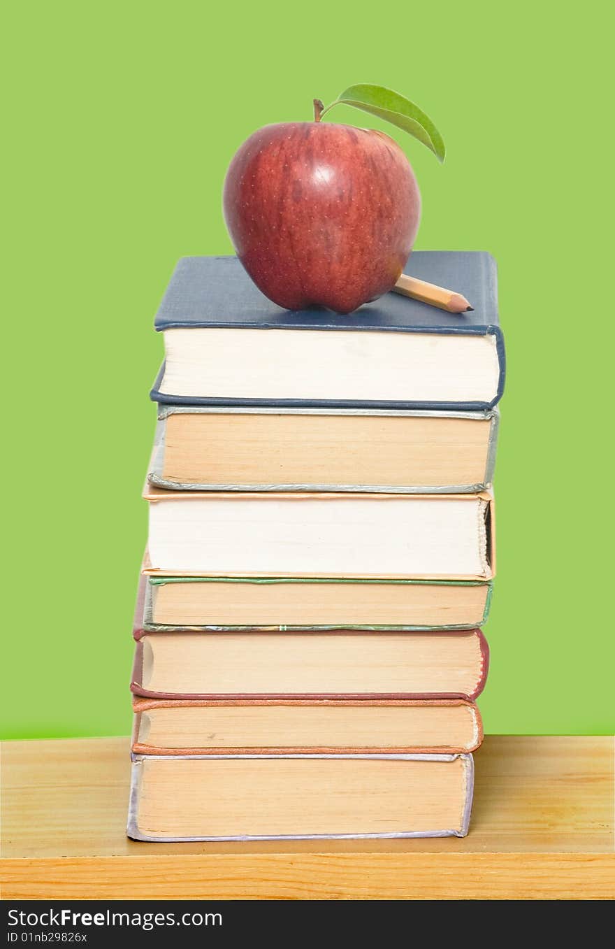 Red apple and pencil on pile of books. Red apple and pencil on pile of books