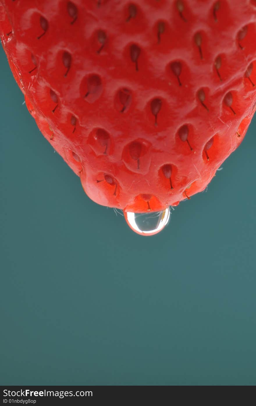 Strawberry with a drop on green background