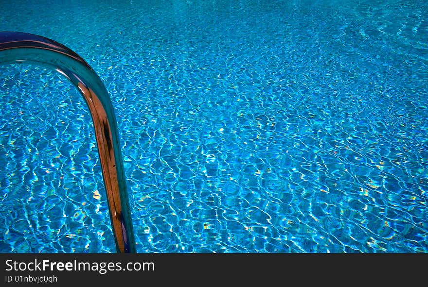 A swimming pool area with bathing ladder. A swimming pool area with bathing ladder