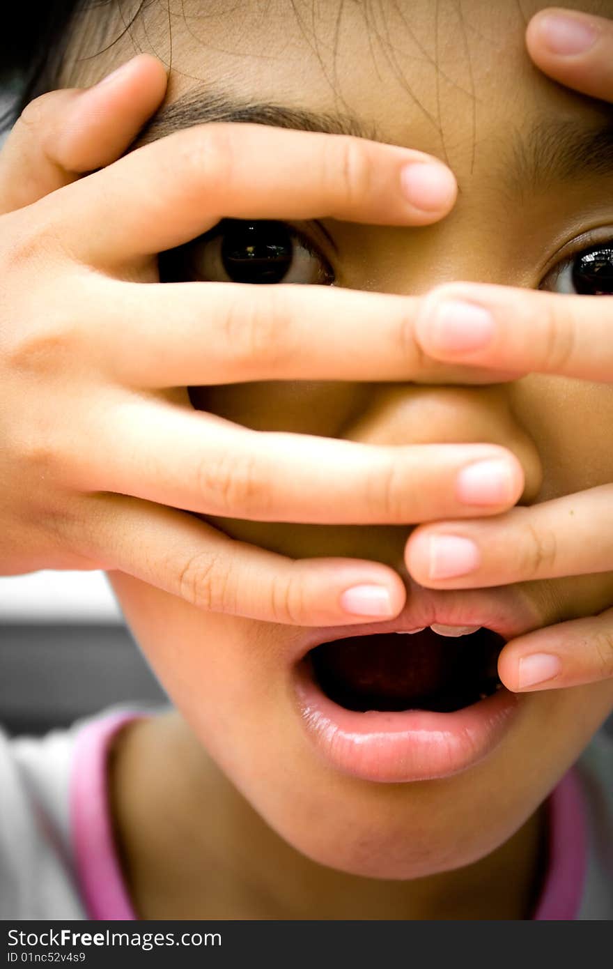 Little girl looks surprised and terrified onto something she saw. putting her fingers over her face. Little girl looks surprised and terrified onto something she saw. putting her fingers over her face.