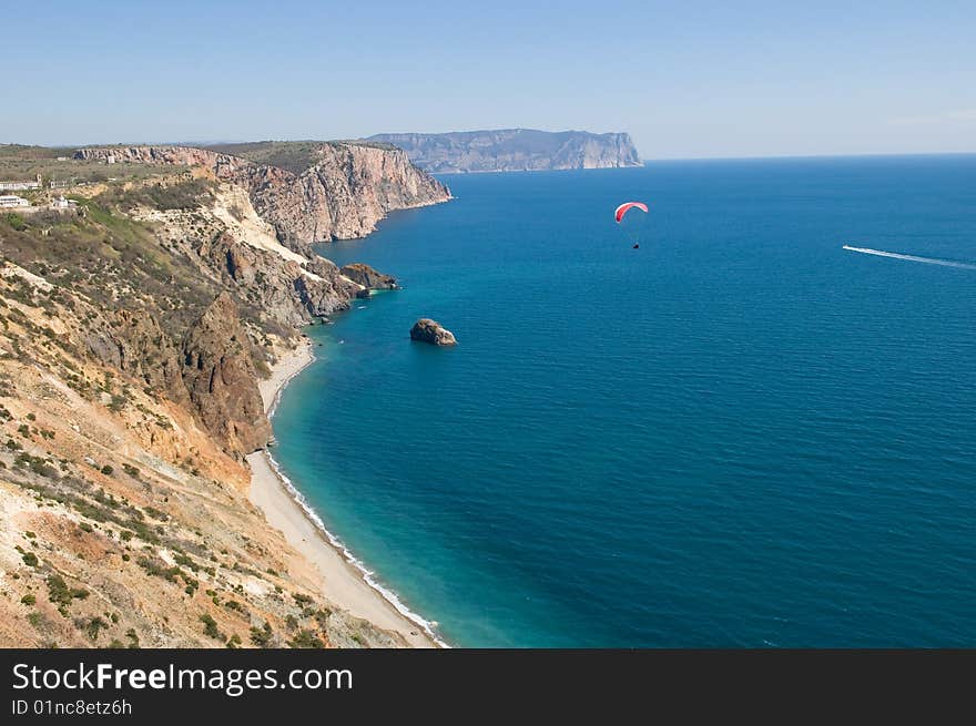 Paraplane fly on by sea and mountain