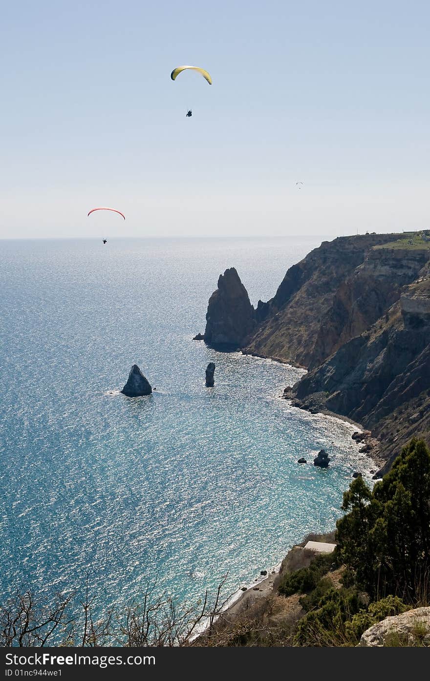 Paraplane fly on by sea and mountain