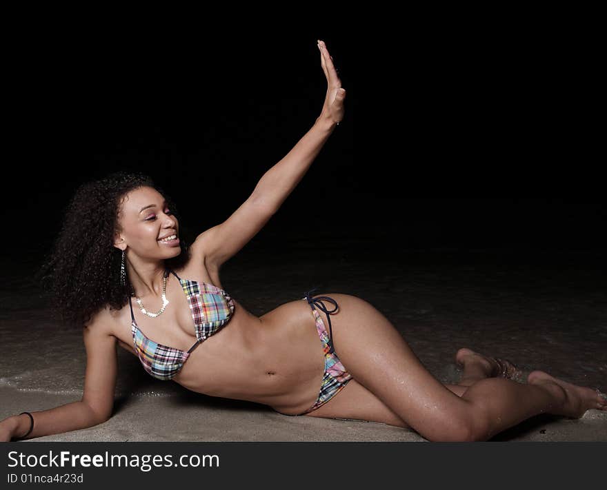 Young woman on the beach at night and waving