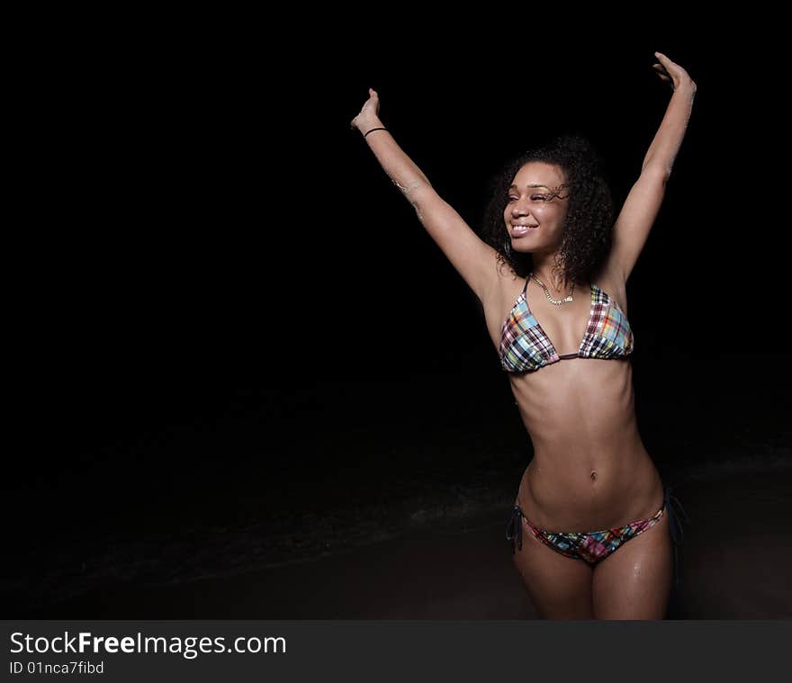 Joyous woman in a bikini extending her arms upward